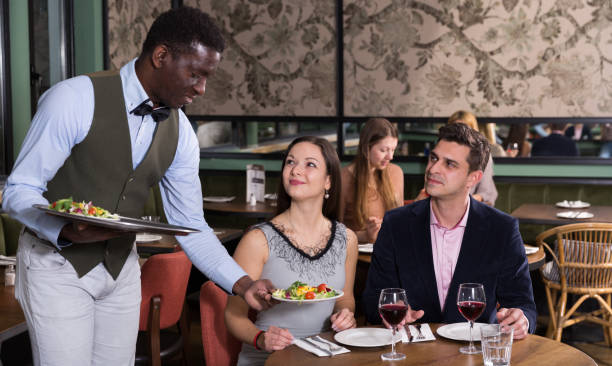istock African American waiter serving couple at restaurant 944657410