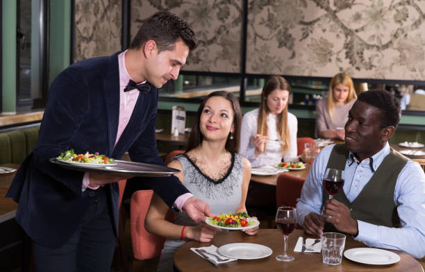 istock Waiter serving couple in restaurant 944657430