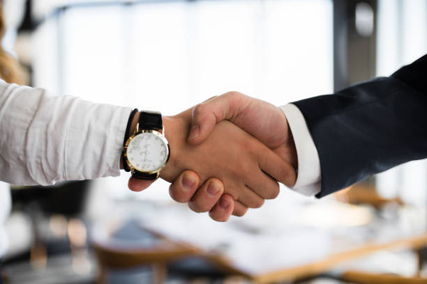 Businesswoman shaking hands with man at restaurant