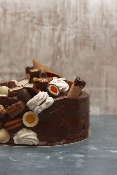 istock A festive chocolate cake decorated with a waffle horn, chocolate sweets, marshmallows, biscuits on a dark background 944676678