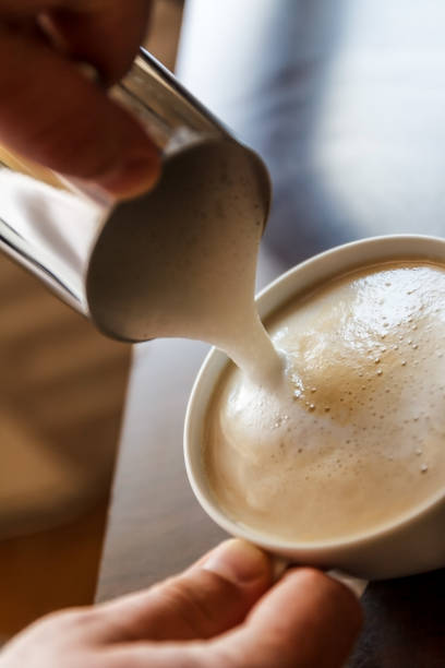 istock man pouring into a cup of coffee with milk 944676790