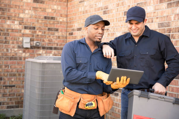 istock Multi-ethnic team of blue collar air conditioner repairmen at work. 944677852