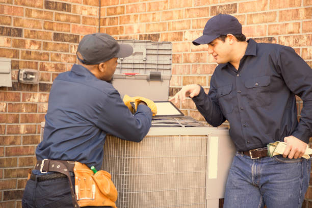 istock Multi-ethnic team of blue collar air conditioner repairmen at work. 944678068