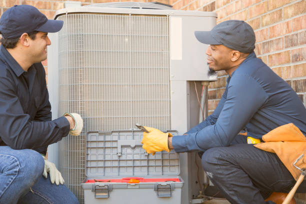 istock Multi-ethnic team of blue collar air conditioner repairmen at work. 944678130