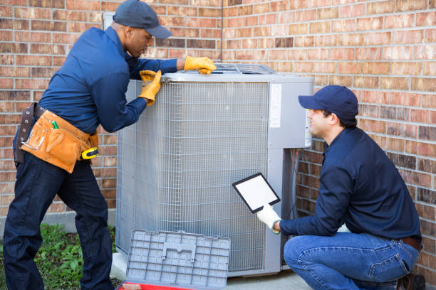 istock Multi-ethnic team of blue collar air conditioner repairmen at work. 944678484