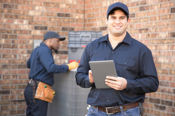 istock Multi-ethnic team of blue collar air conditioner repairmen at work. 944678546