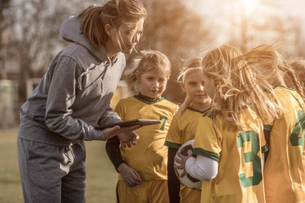 giovane bionda donna allenatore di calcio e la sua squadra di calcio ragazza - strategy coach soccer digital tablet foto e immagini stock