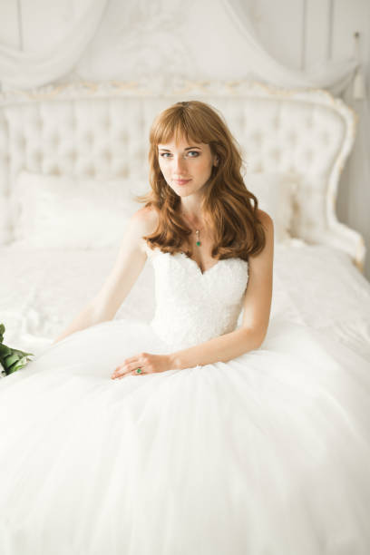 istock Gorgeous bride in robe posing and preparing for the wedding ceremony face in a room 944690546