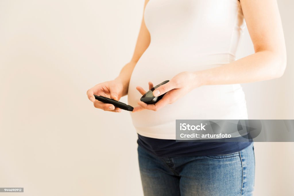 Schwangere Frau, die Kontrolle des Blutzuckerspiegels. Schwangerschafts-Diabetes. Schwangerschaft-Gesundheit - Lizenzfrei Schwangerschaftsdiabetes Stock-Foto