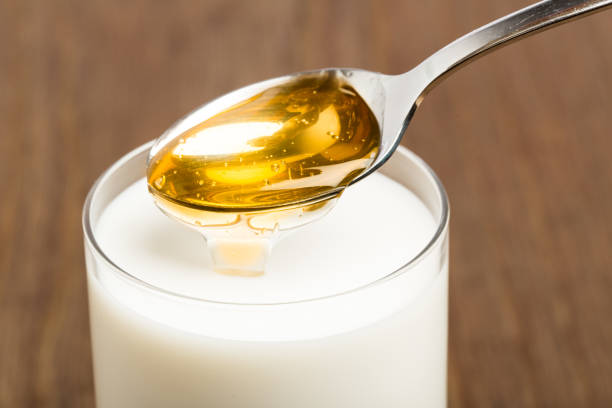 leche de miel aislada sobre fondo marrón - close to cold colors color image fotografías e imágenes de stock