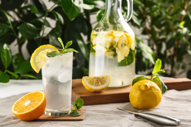 ヴィンテージ デカンタの横にガラス カップ氷と柑橘ミント レモネード。夏の飲�み物のリモンチェッロ - juice carafe glass decanter ストックフォトと画像