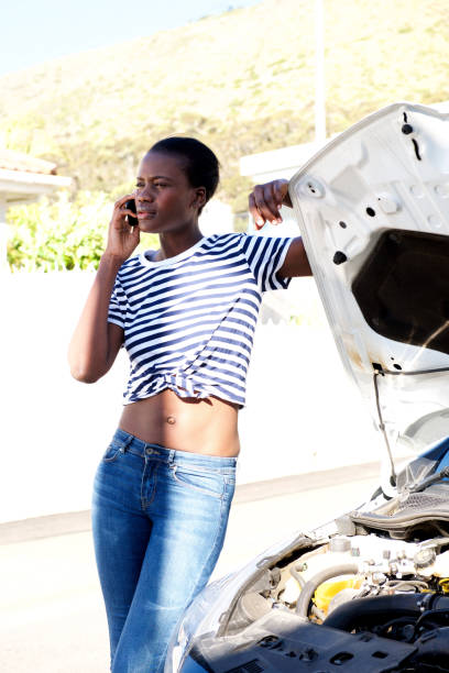 istock black woman standing by broken down car and calling for assistance on mobile phone 944698450