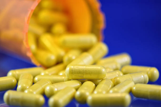 желтая медицина таблетки капсулы открыть рецепт контейнер фармацевтической промышленности - store herbal medicine drug abuse capsule стоковые фото и изображения