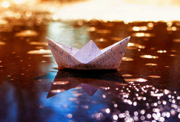 istock school small paper boat from a cellular notebook floats in the Sunny spring early puddle 944699986