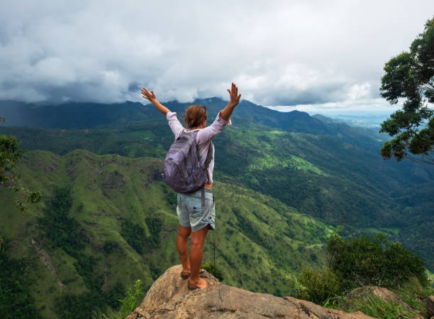 randonneur de jeune femme caucasienne avec sac à dos, debout au sommet de la montagne et profiter de vue panoramique au sommet de ella - ella sri lanka photos et images de collection