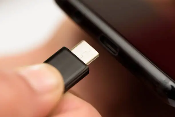 Photo of Hand inserting a USB cable charger