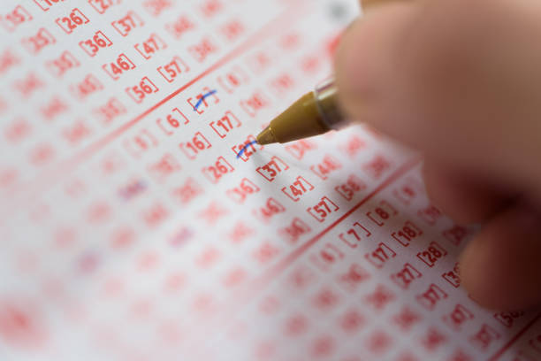 istock Hand Marking Number On Lottery Ticket 944723352