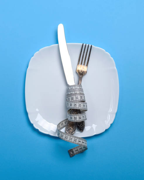 istock knife with a fork wrapped in a measuring tape with  ceramic plate 944724110