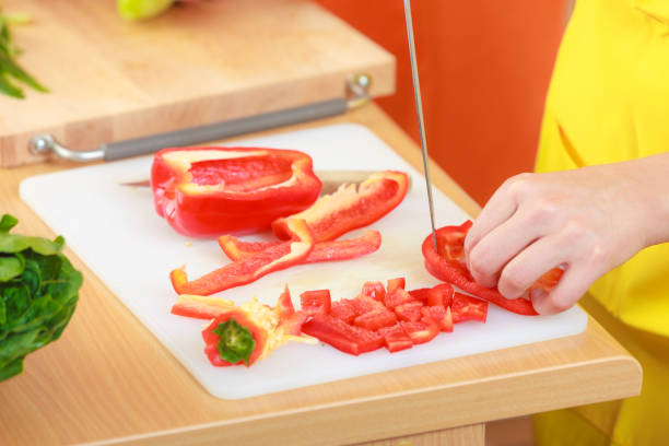 istock Woman preparing vegetables salad slicing red pepper 944724132