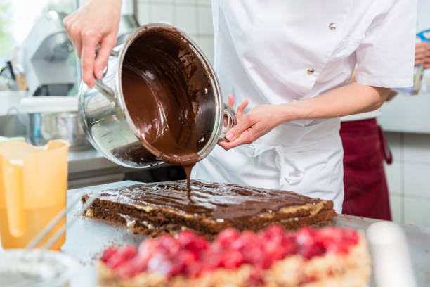 istock Confectioner putting chocolate as frosting on cake 944730232
