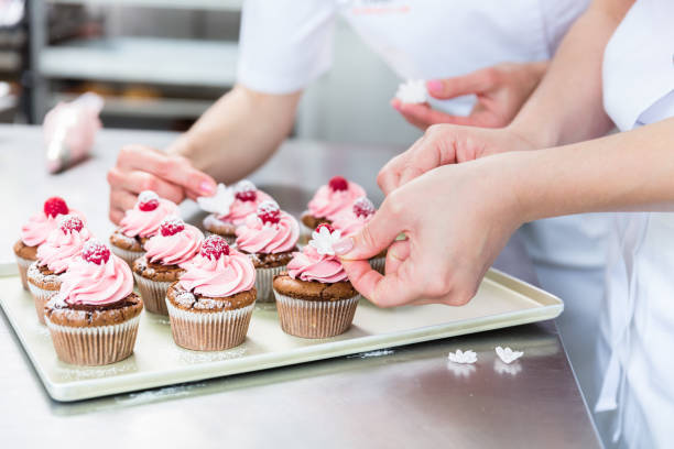 istock Women in pastry bakery working on muffins 944732136