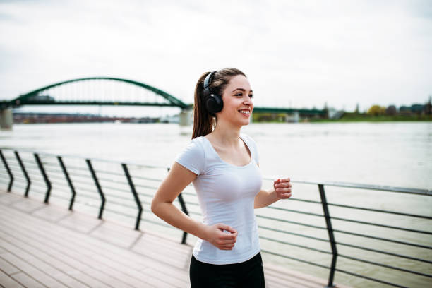 istock Smiling runner girl listening music. 944734044