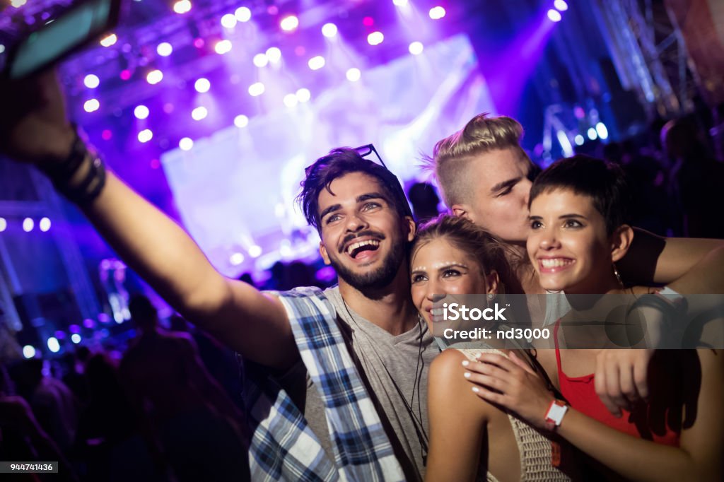 Happy friends having fun at music festival Happy young friends having fun at music festival Selfie Stock Photo