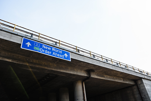 A low angle view of a blue traffic road sign with the message \