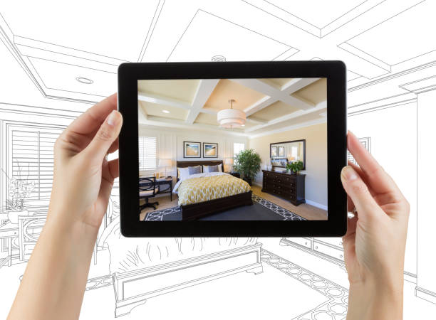istock Female Hands Holding Computer Tablet with Bedroom Photo on Screen, Drawing Behind. 944751410