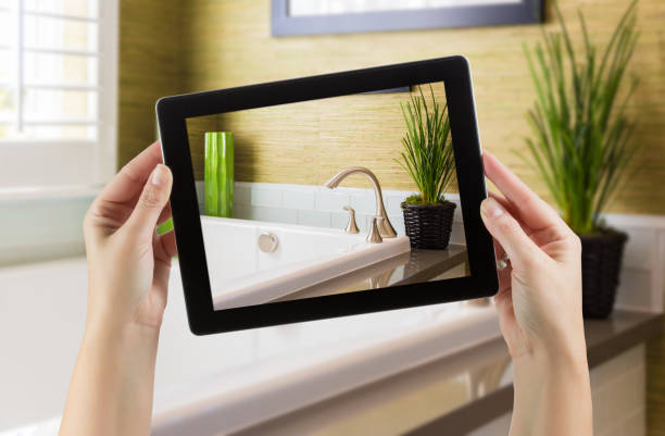istock Female Hands Holding Computer Tablet In Bathroom with Photo on Screen. 944751490