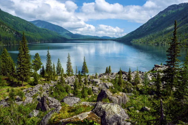 istock Lake in the mountains surrounded by old trees and large boulders. 944752306