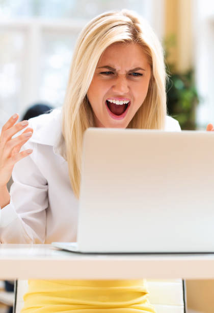 istock Unhappy young woman sitting at her desk 944766896