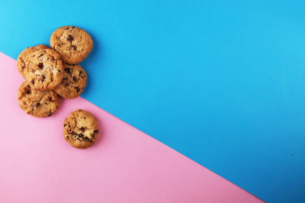 istock Chocolate cookies flat lay on colored paper. 944770982
