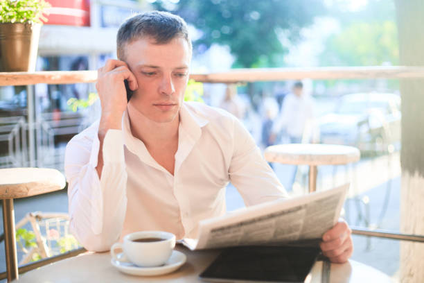 istock Young man drinking coffee in cafe and using phone. 944771340