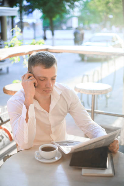 istock Young man drinking coffee in cafe and using phone. 944771452