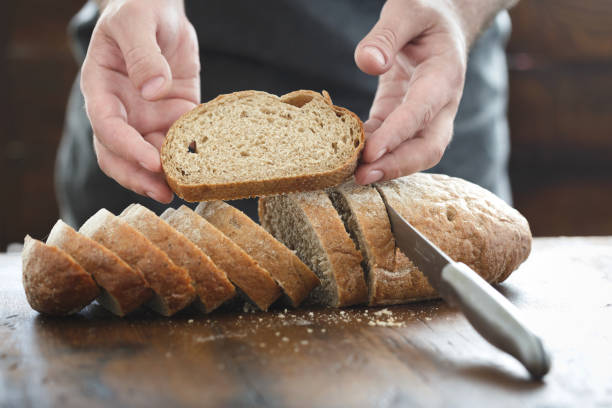 istock Close up male hands hold fresh slice of bread 944774466
