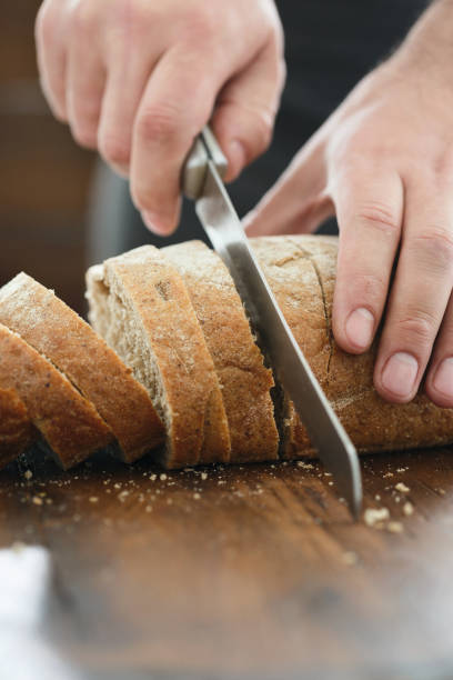 istock Male hands chopped fresh bread close-up 944774558