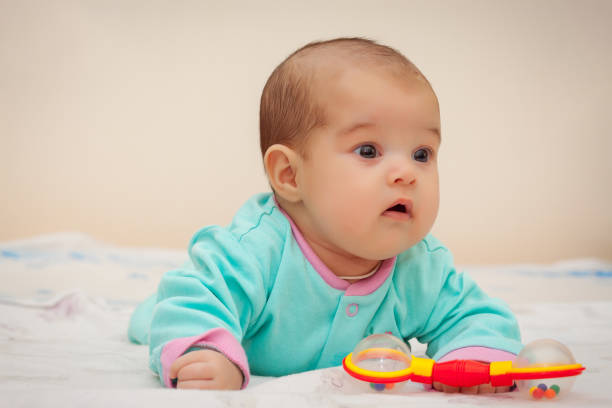 istock Baby in bed with a colorful toy 944774668