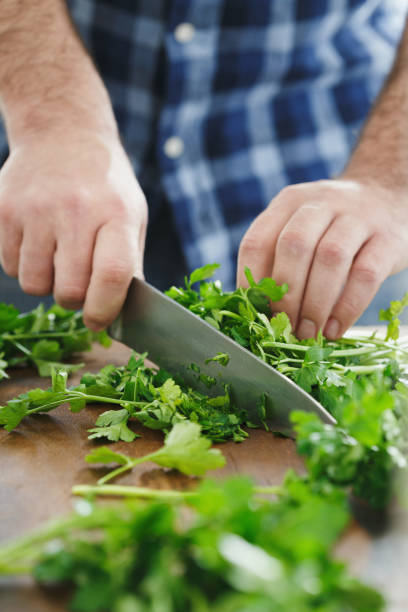 istock Male hands chopping fresh parsley, close-up 944774858