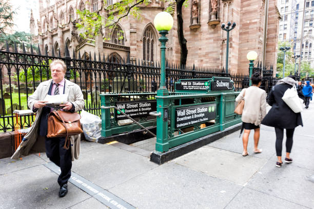 broadway st by wall street, ludzie, biznesmen z gazetą spaceru od stacji metra przez trinity church w nyc manhattan dzielnicy finansowej centrum, nyse - people in a row in a row business office worker zdjęcia i obrazy z banku zdjęć