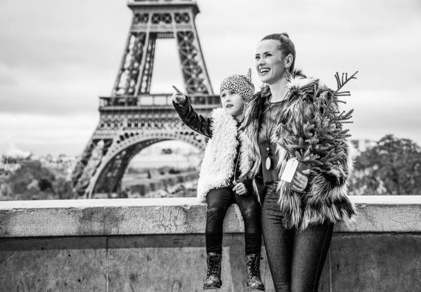 mother and daughter with Christmas tree pointing on something