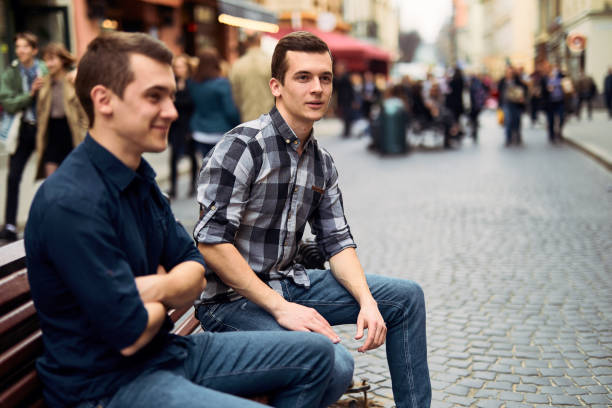 istock Two man sit on bench and talk on the street 944778890