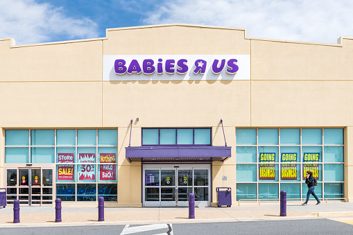 Sterling, USA - April 4, 2018: Babies R US store in Fairfax County, Virginia for children shop exterior entrance with sign, logo, doors, closing going out of business bankruptcy, woman walking