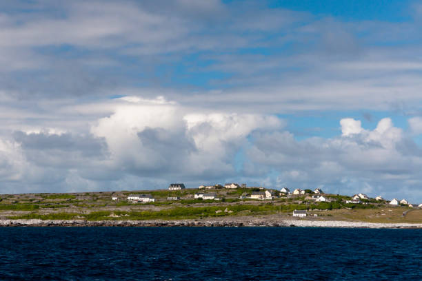 View of Inisheer from Doolin Ferry Looking west toward Inisheer after the Doolin Ferry to Inisheer passes the Plassey wreck.  View of a place named Sheeaunroe from the ferry deck.  Inisheer, Aran Islands, County Galway, Republic of Ireland michael stephen wills aran stock pictures, royalty-free photos & images