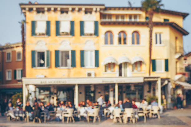 Blurred people sitting at the table in street cafe. Old Italian town.