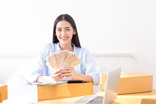 Joven asiática mujer trabajando en el hogar, joven propietario mujer comenzar para los negocios en línea. Gente en línea compras concepto del PYME empresario o autónomo del trabajo. photo