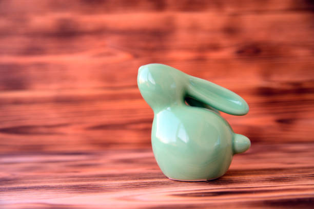 auf hölzernen hintergrund einer keramik osterhase. - ceramic figure stock-fotos und bilder