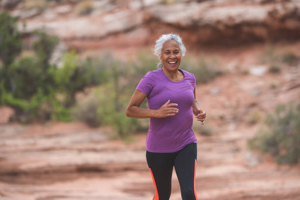старшая женщина собирается на след бежать в пустыне - senior adult running jogging senior women стоковые фото и изображения