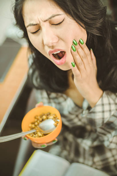 Jovem mulher que sofre com dor de dente. - foto de acervo