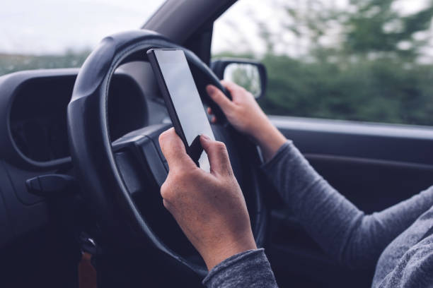 istock Woman simultaneously driving car and typing text message 944815372